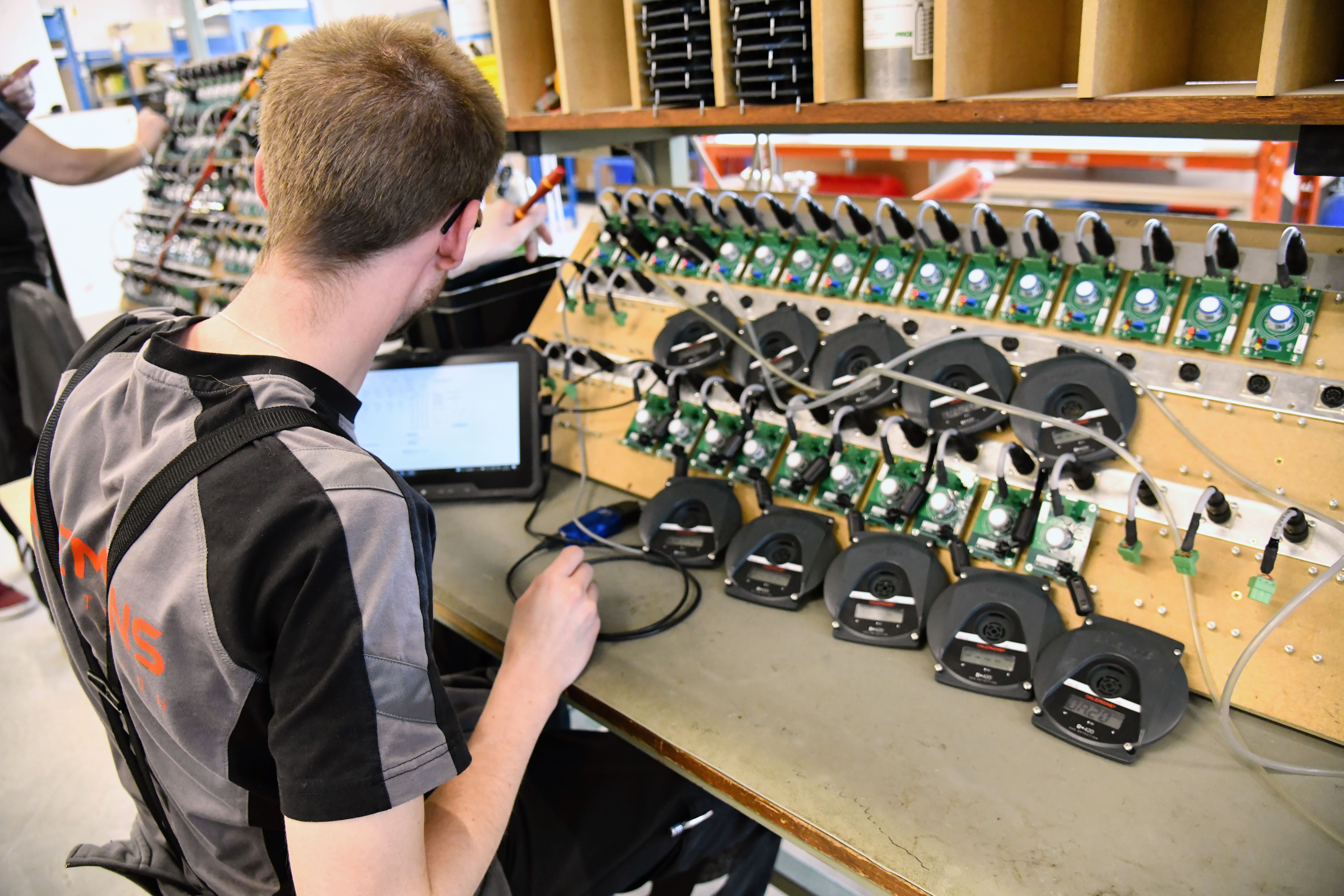 Dalemans-technicus die een gasdetector test op een elektronisch controlecentrum